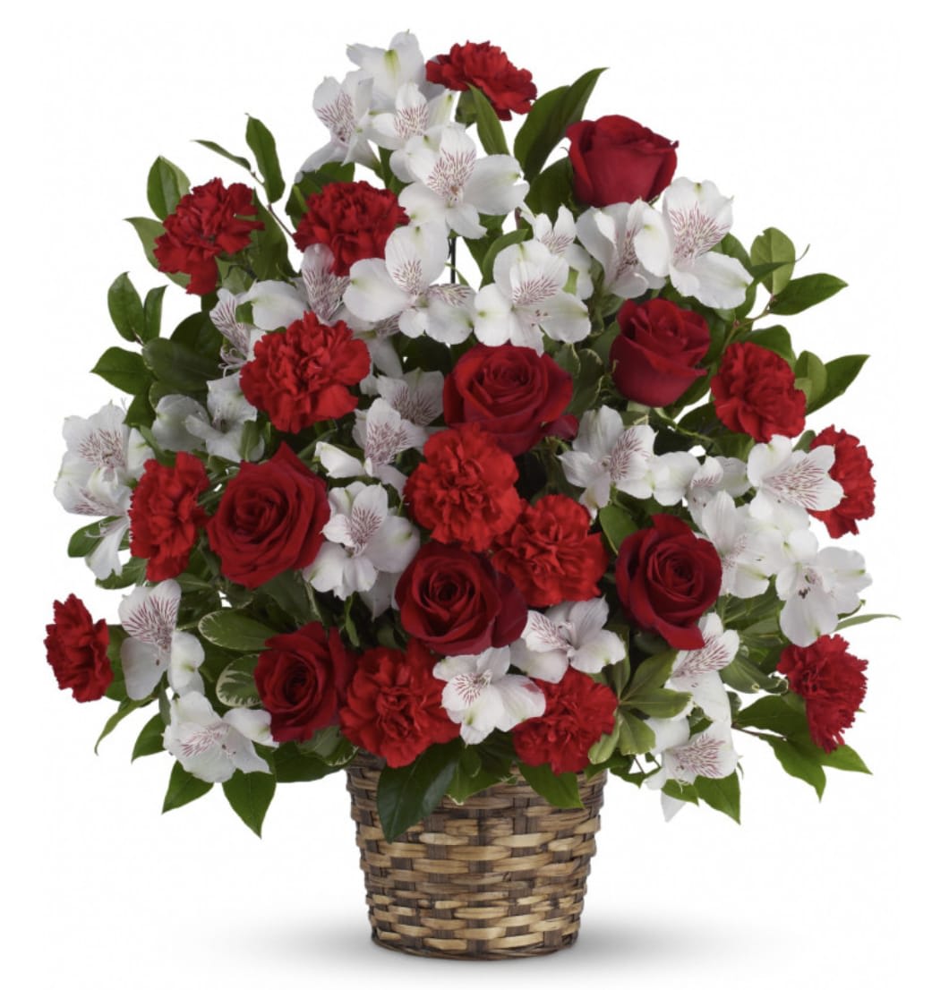 Red roses and carnations with white alstroemeria in a woven basket