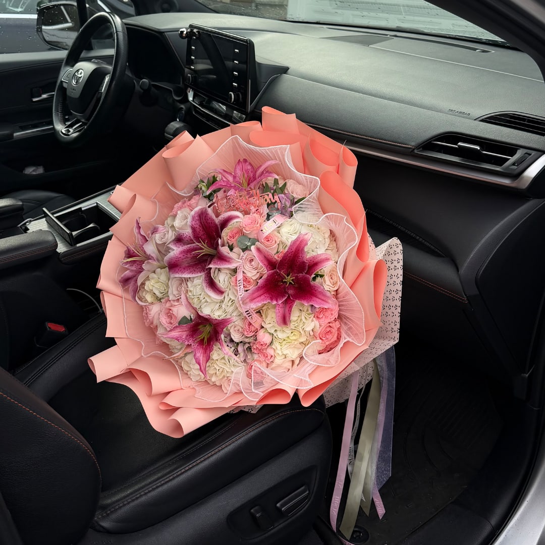Pink and white bouquet with lilies and roses on a car seat
