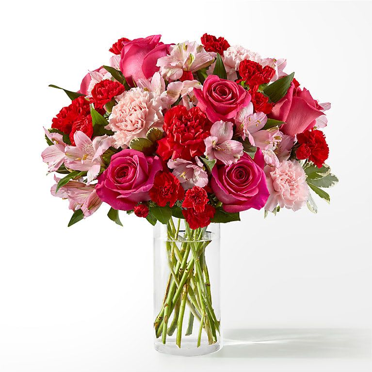 Pink and red mixed flower bouquet in a clear glass vase