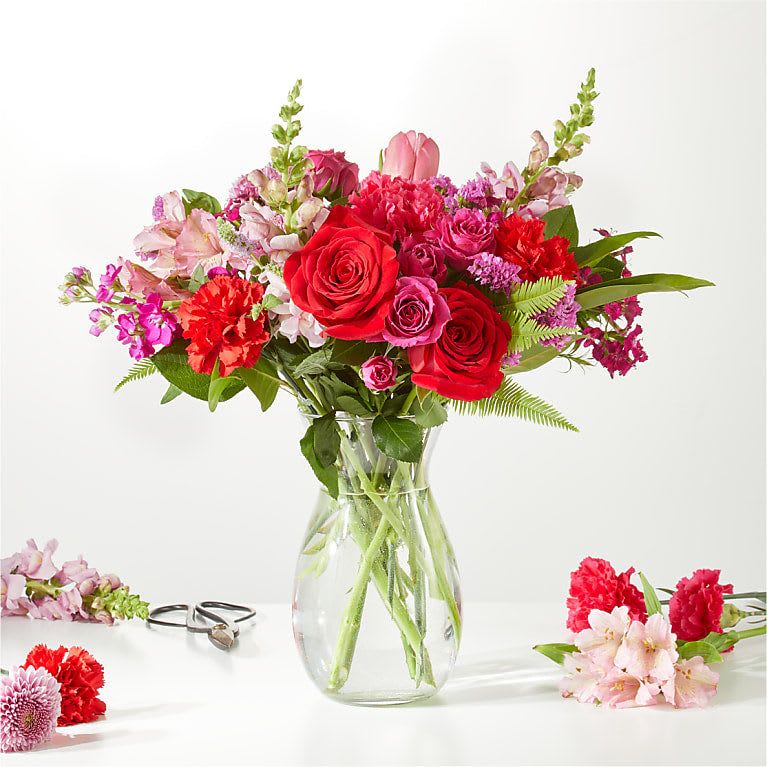 Red and pink mixed bouquet in a clear glass vase
