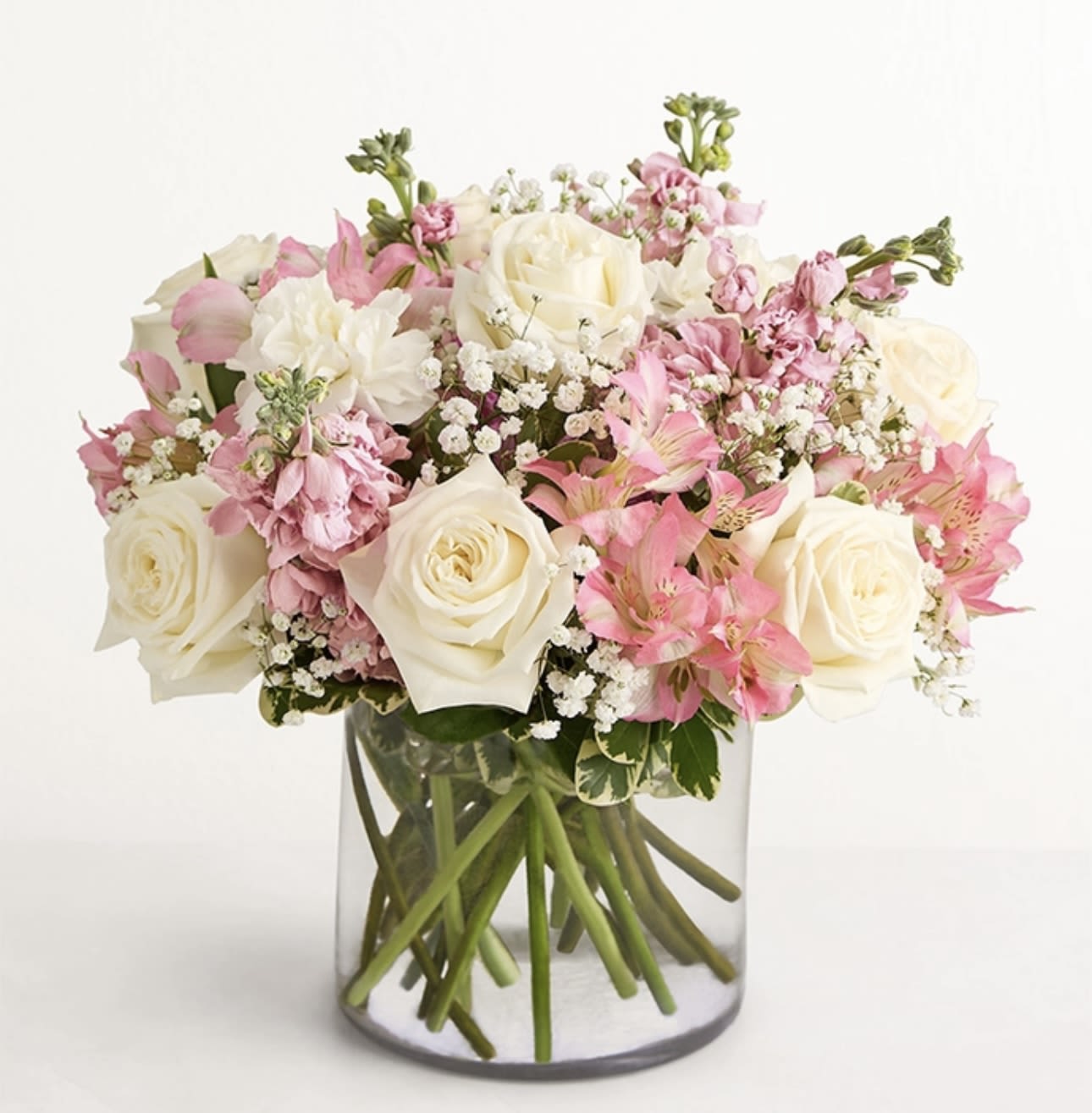 Pink and white roses arranged in a clear glass vase