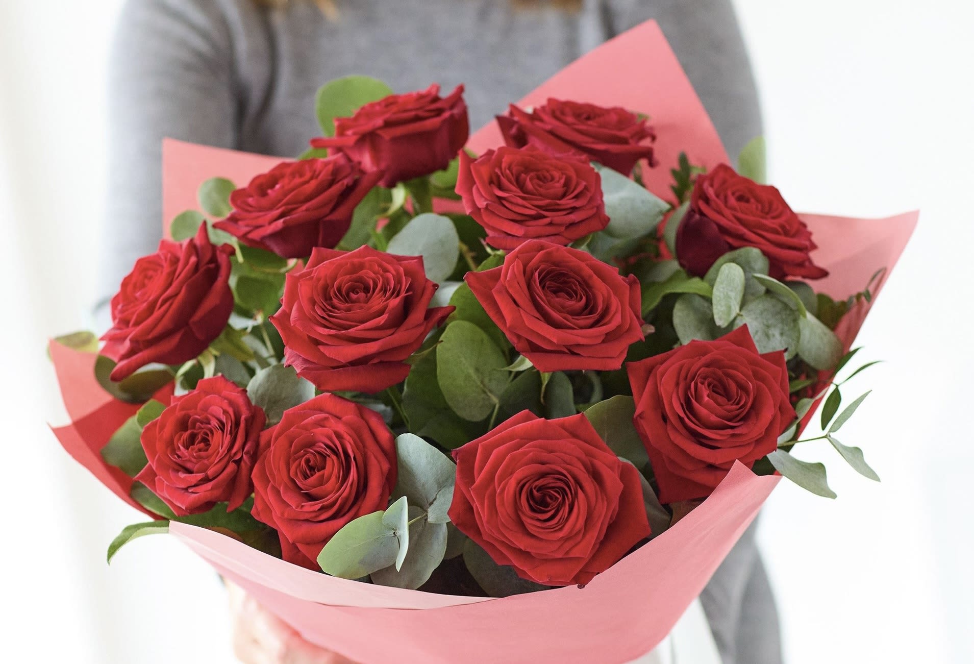 Bouquet of red roses wrapped in pink paper