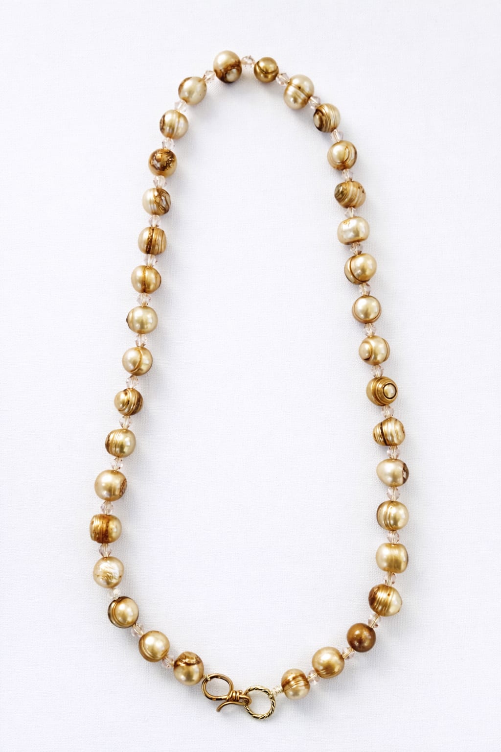Gold beaded necklace on a white background