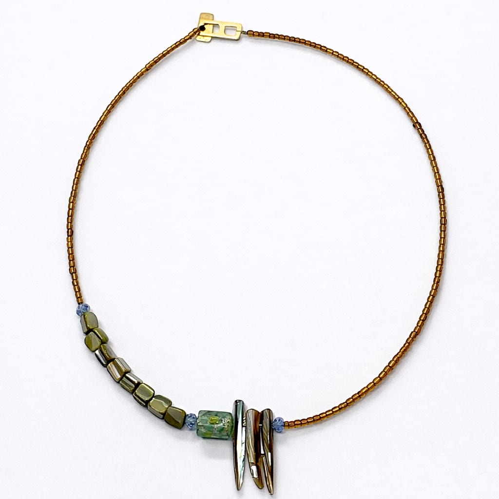 Beaded necklace with green and metallic beads on a white background