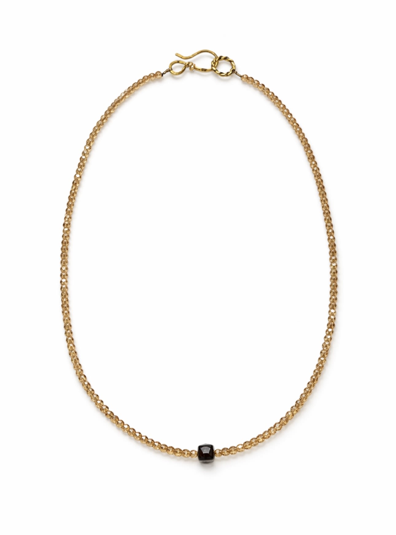 Gold beaded necklace with a small black pendant on a white background