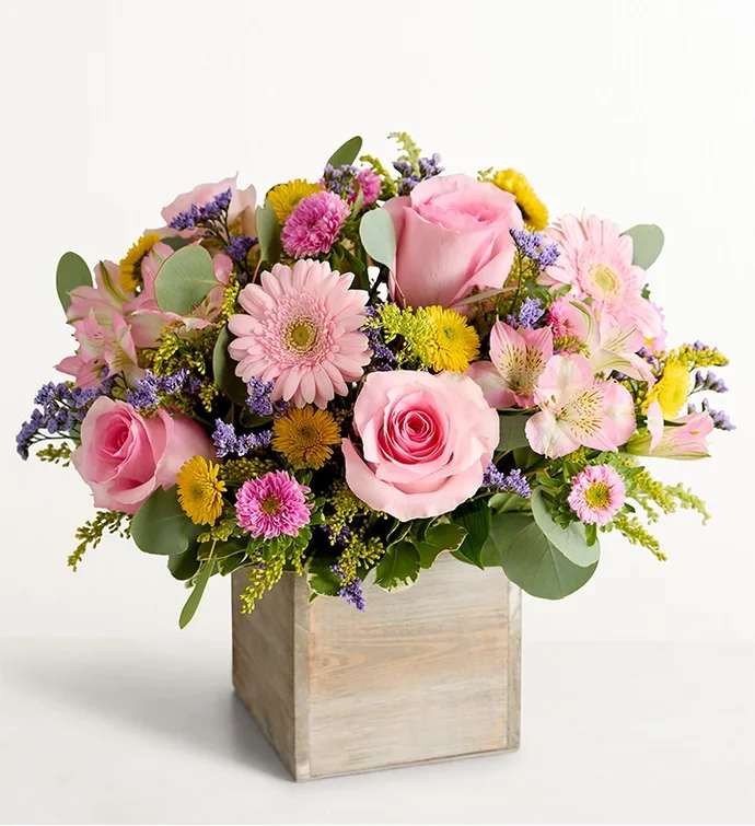 Pink roses and mixed pastel flowers in a wooden box