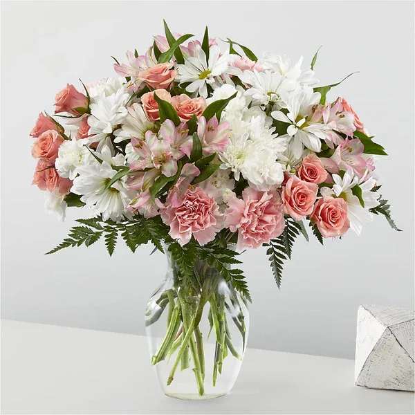 Pink roses and white daisies in a clear glass vase
