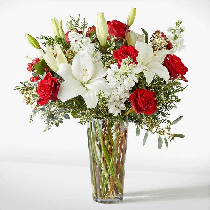 Red roses and white lilies in a clear glass vase