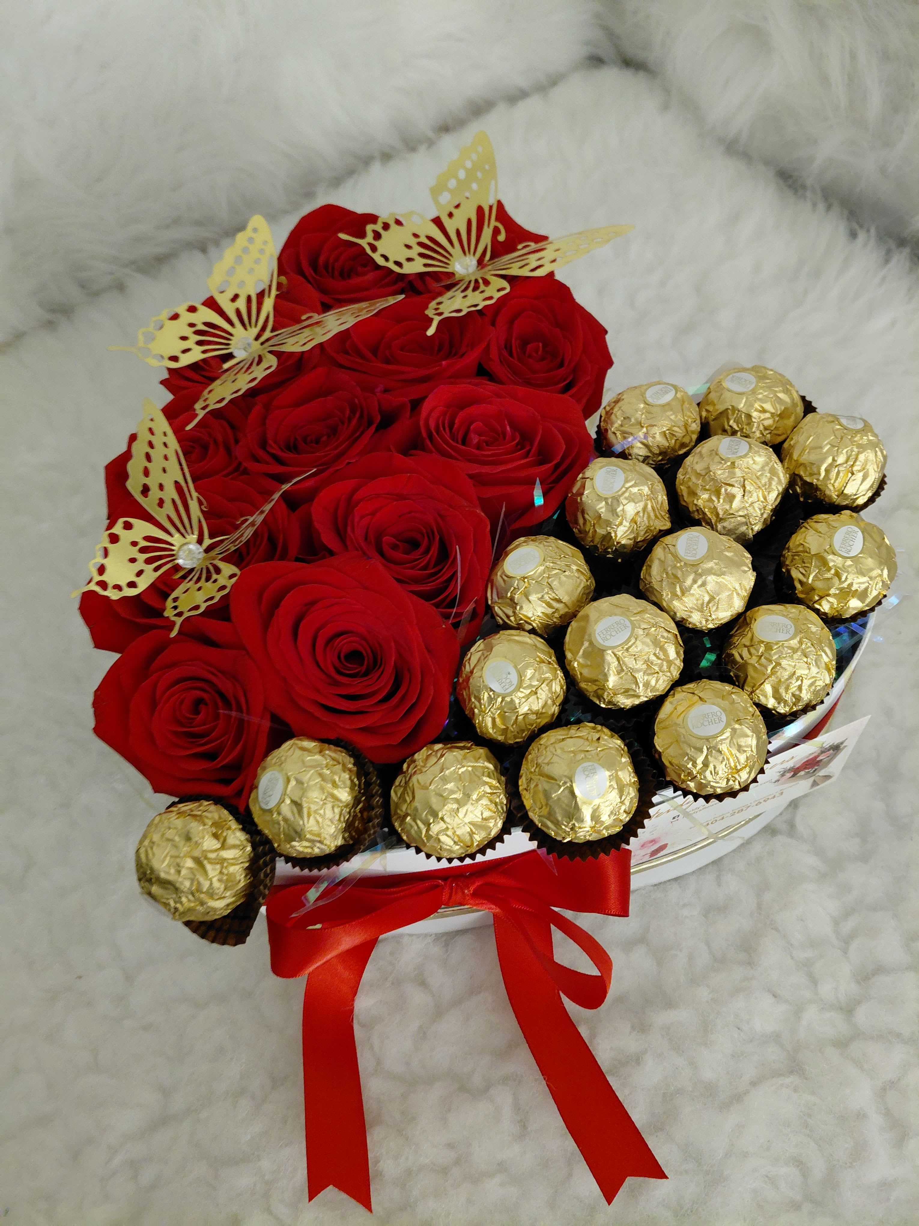 Heart-shaped box. - Heart-shaped box with red roses, chocolates, and butterflies.