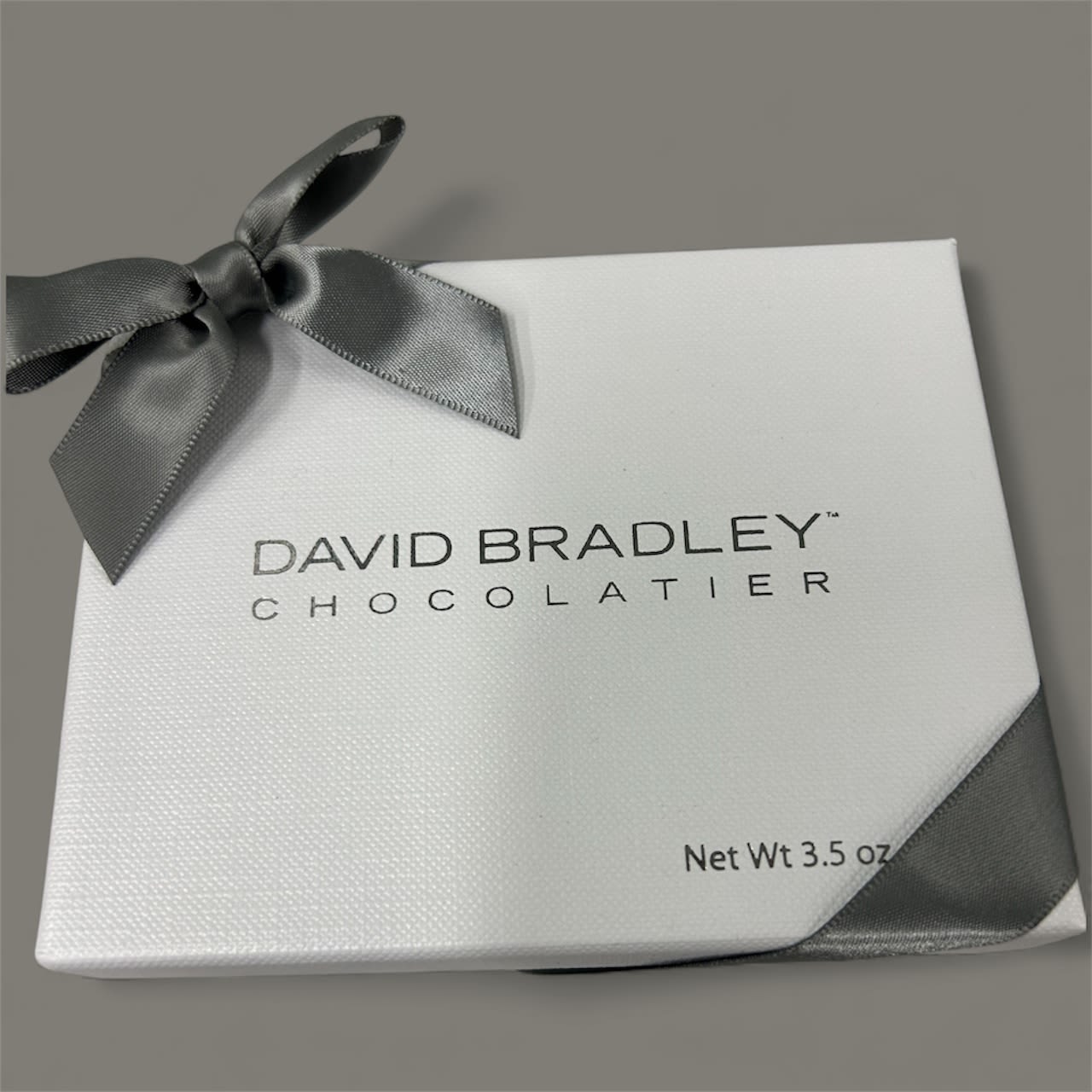 White chocolate gift box tied with a gray ribbon