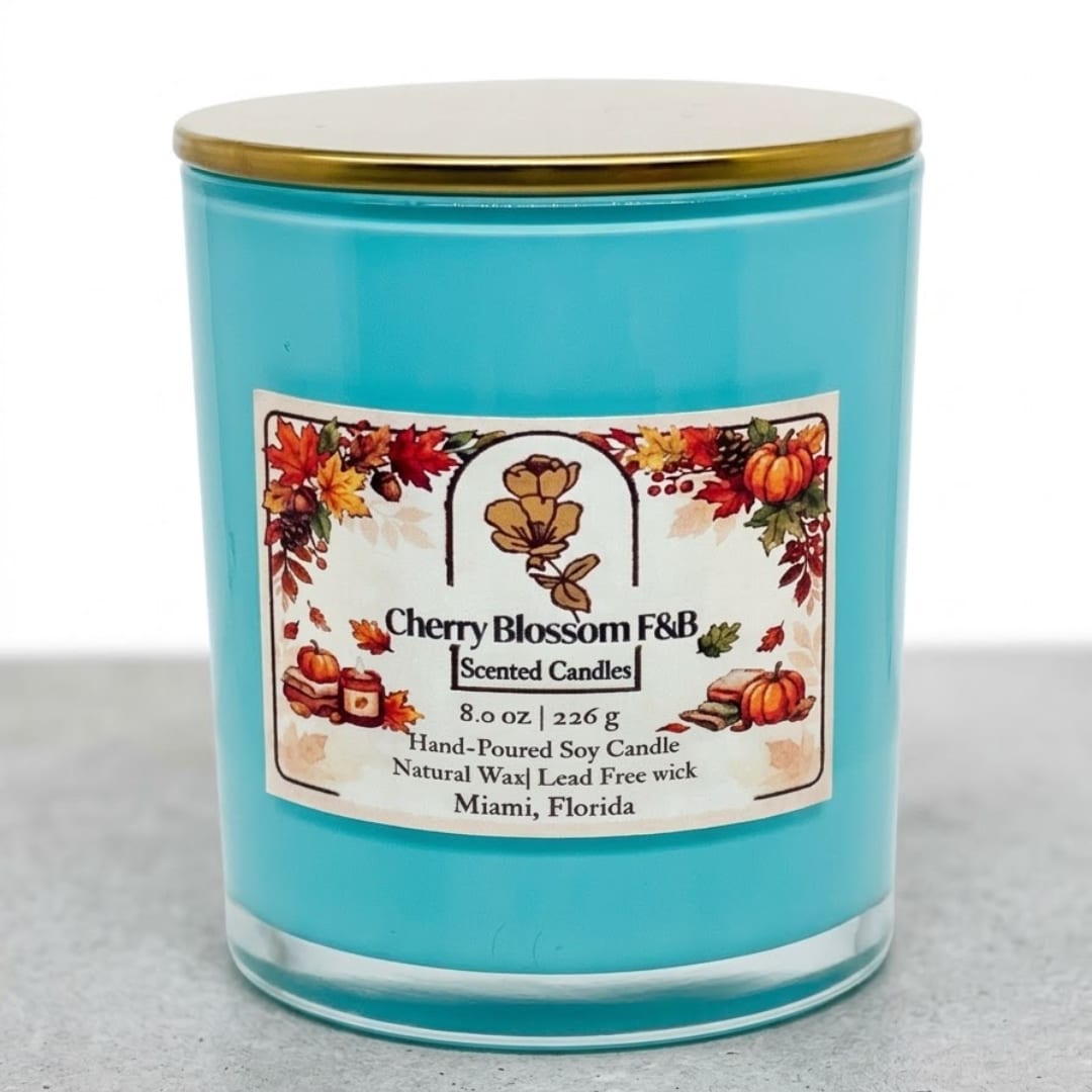 Turquoise scented candle in a glass jar with a gold lid and autumn label