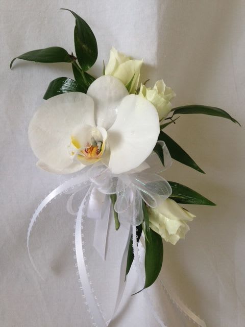 White orchid bouquet with ribbon and dark green leaves