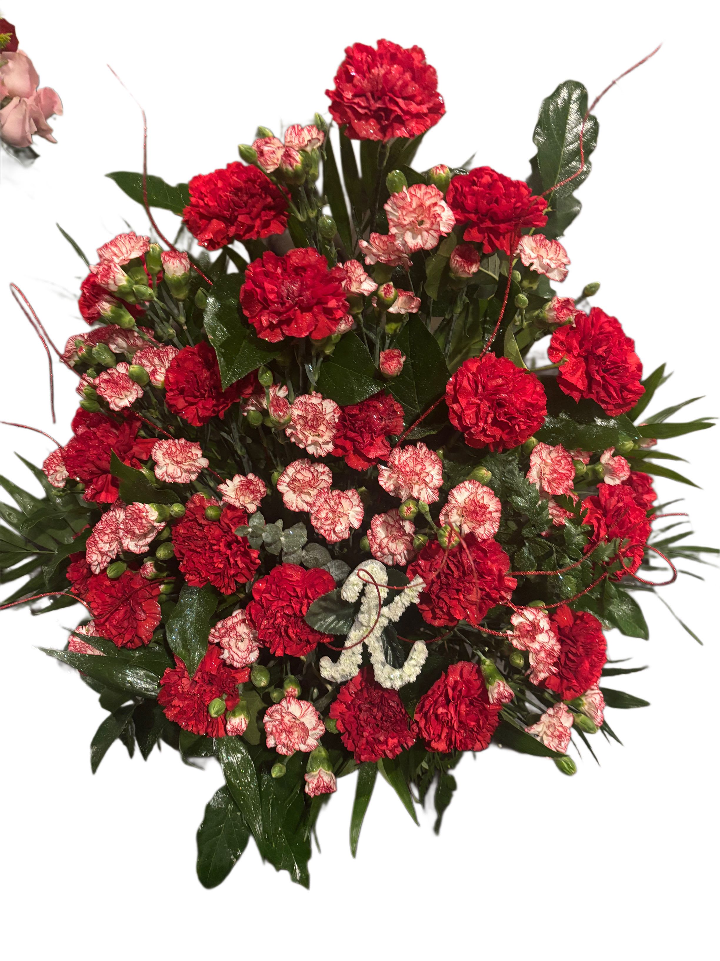 Red and pink carnation arrangement with dark greenery