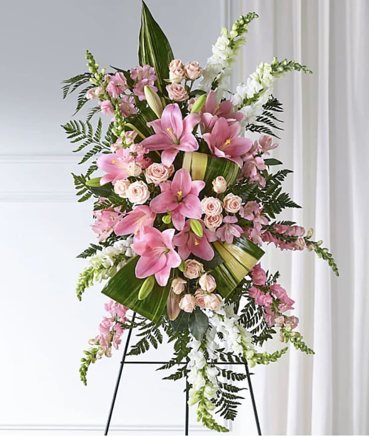 Pink lilies and roses arranged on a standing easel