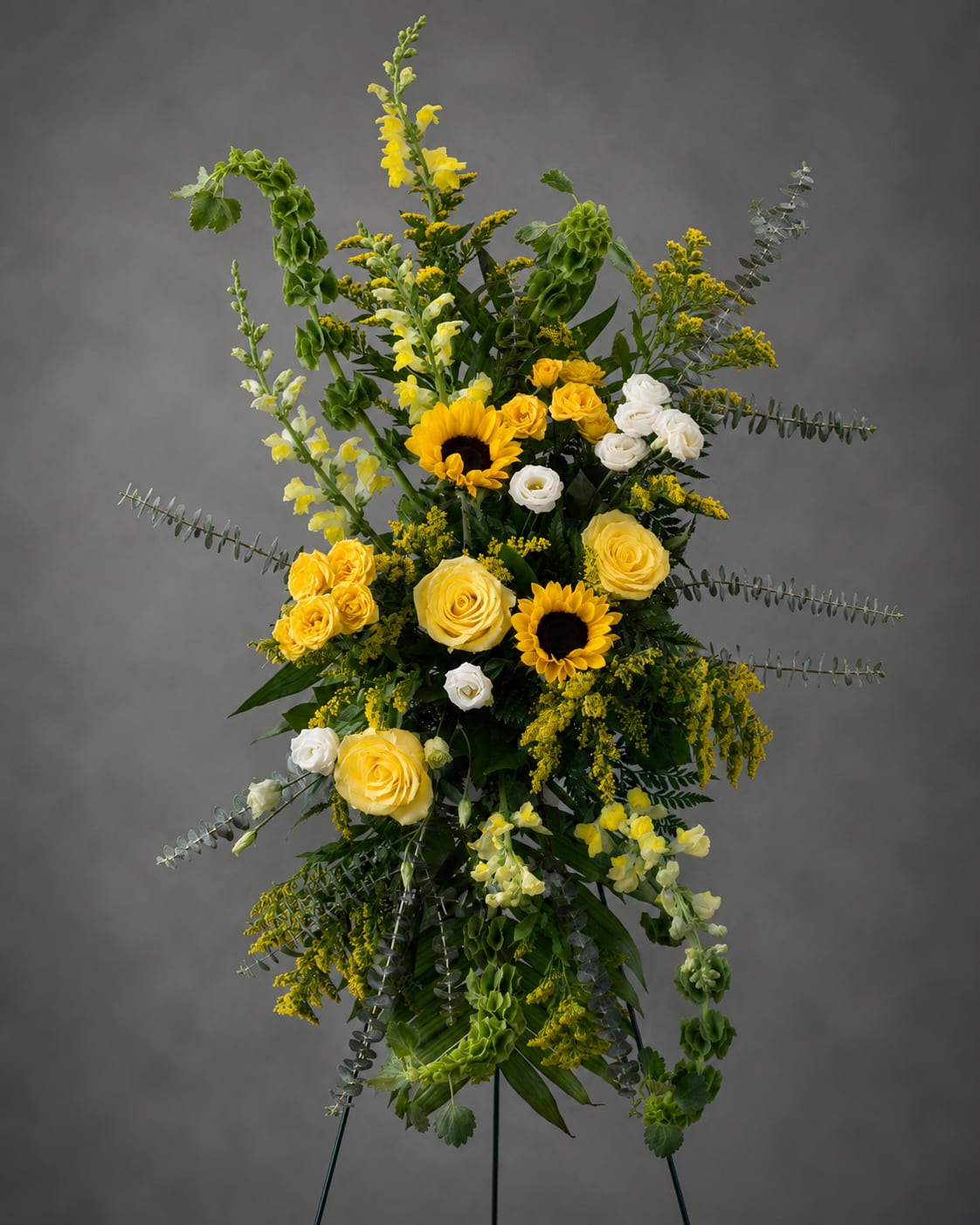 Tall yellow and white floral standing spray on an easel