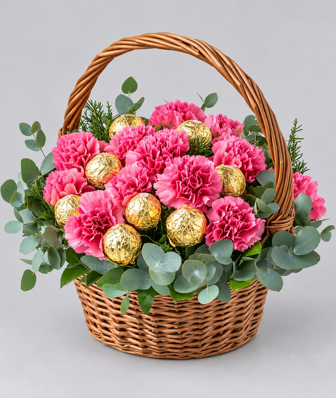 Pink carnations and gold foil chocolates in a wicker basket