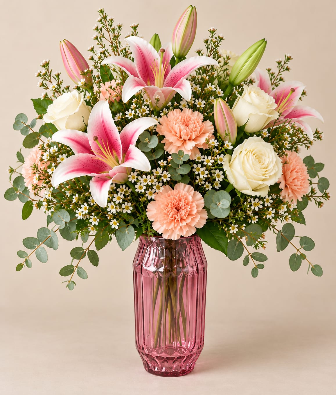 Pink lilies and white roses in a pink glass vase