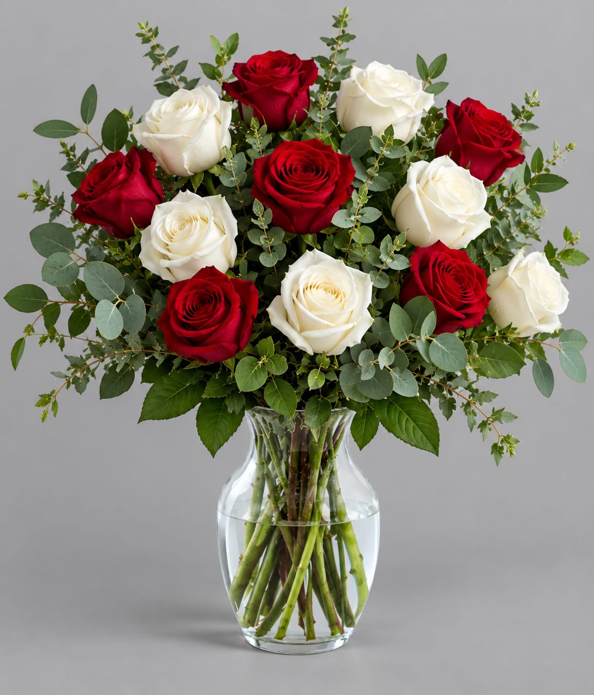 Red and white roses in a clear glass vase