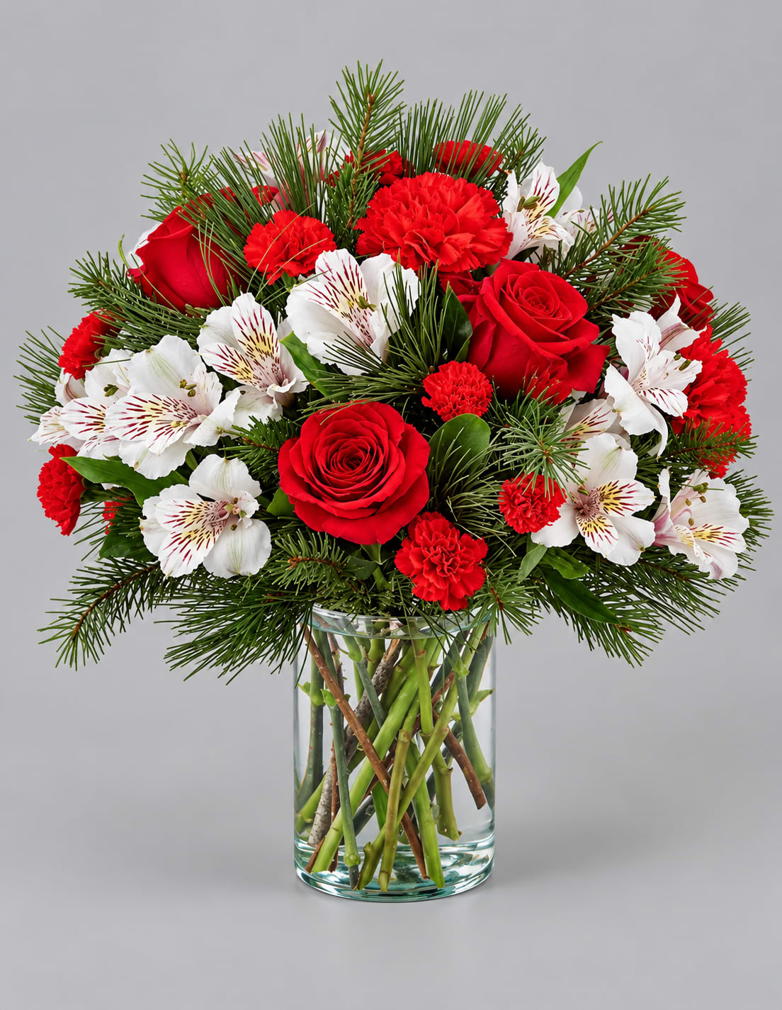 Red roses and carnations with white alstroemeria in a glass vase