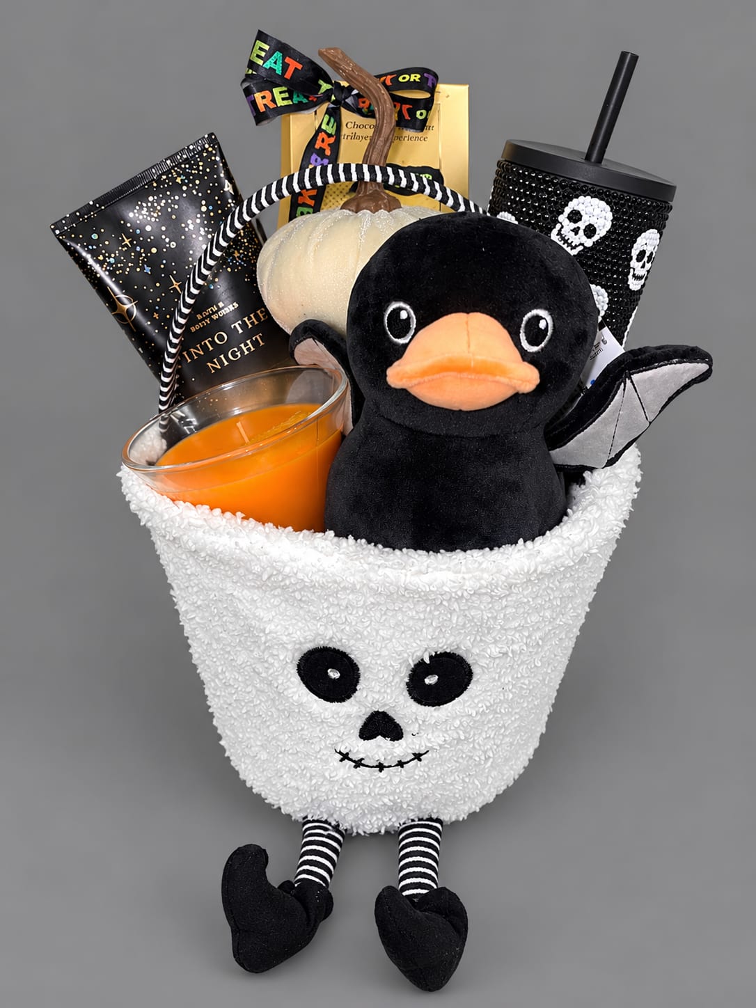 Halloween gift basket with a plush duck, candle, candy, and spooky cup