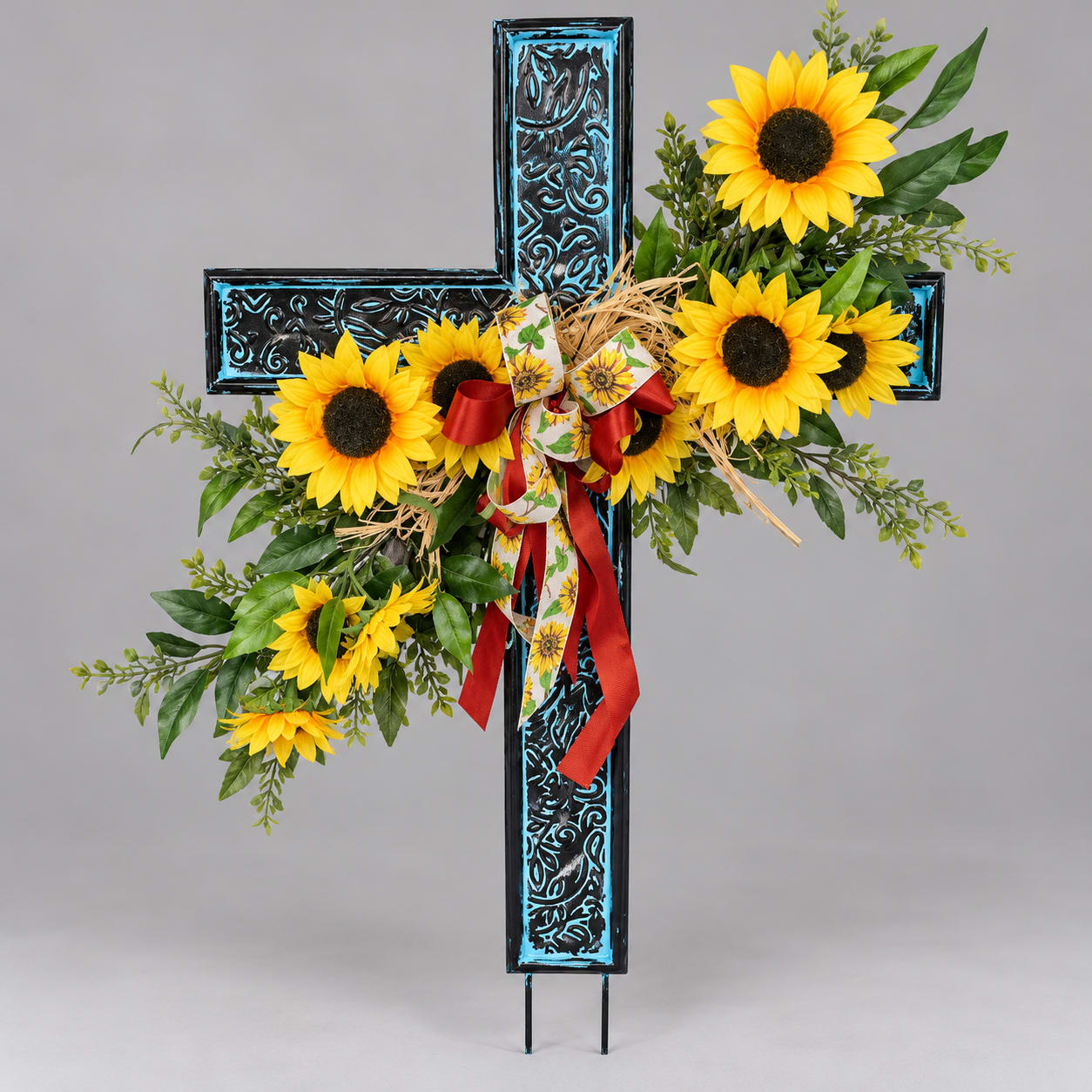 Sunflower arrangement on a decorative cross with ribbon
