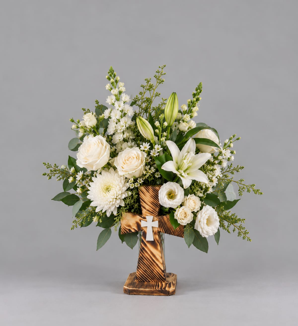 White floral arrangement in a wooden cross stand