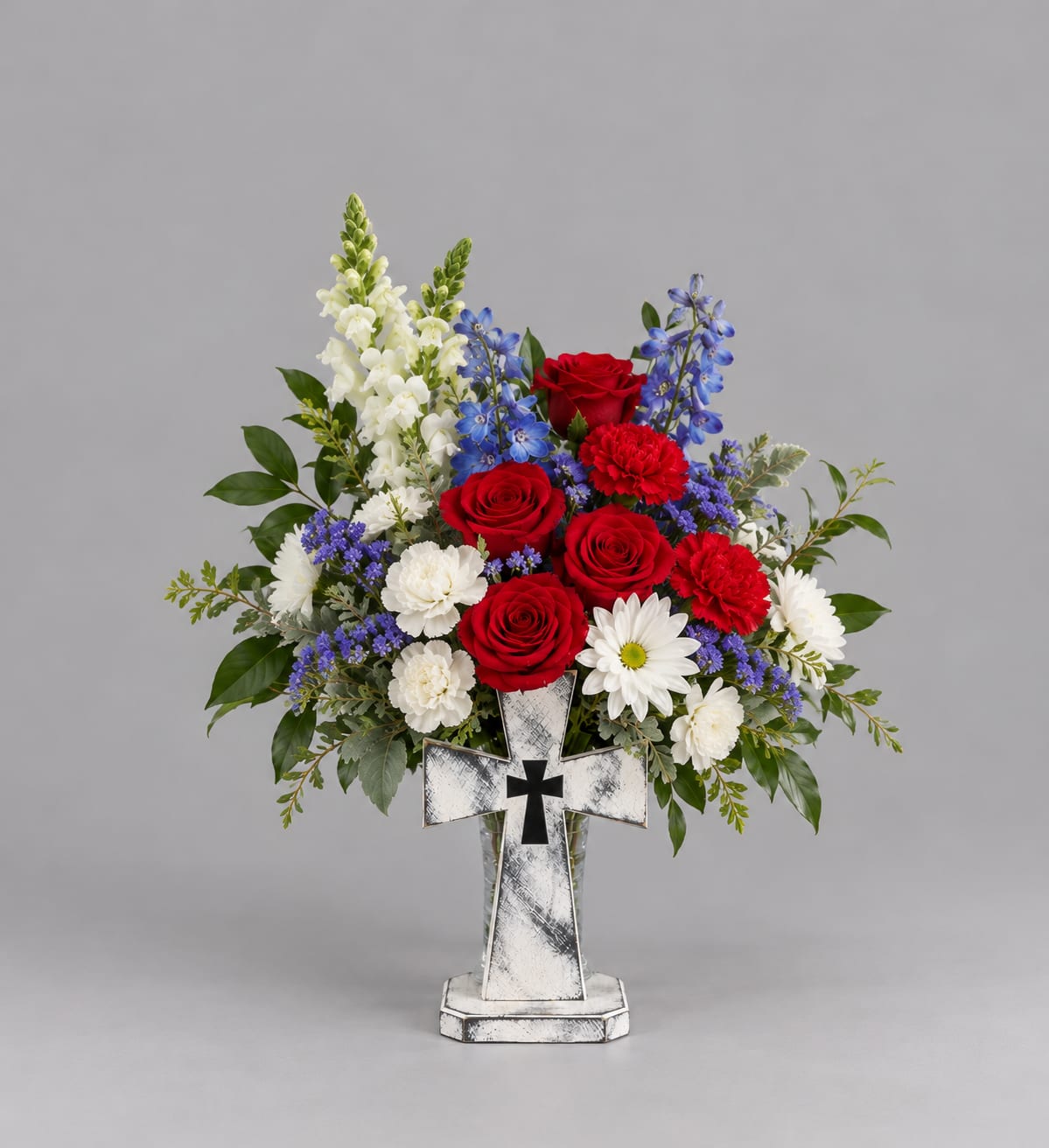 Red roses and white flowers in a cross-shaped vase arrangement