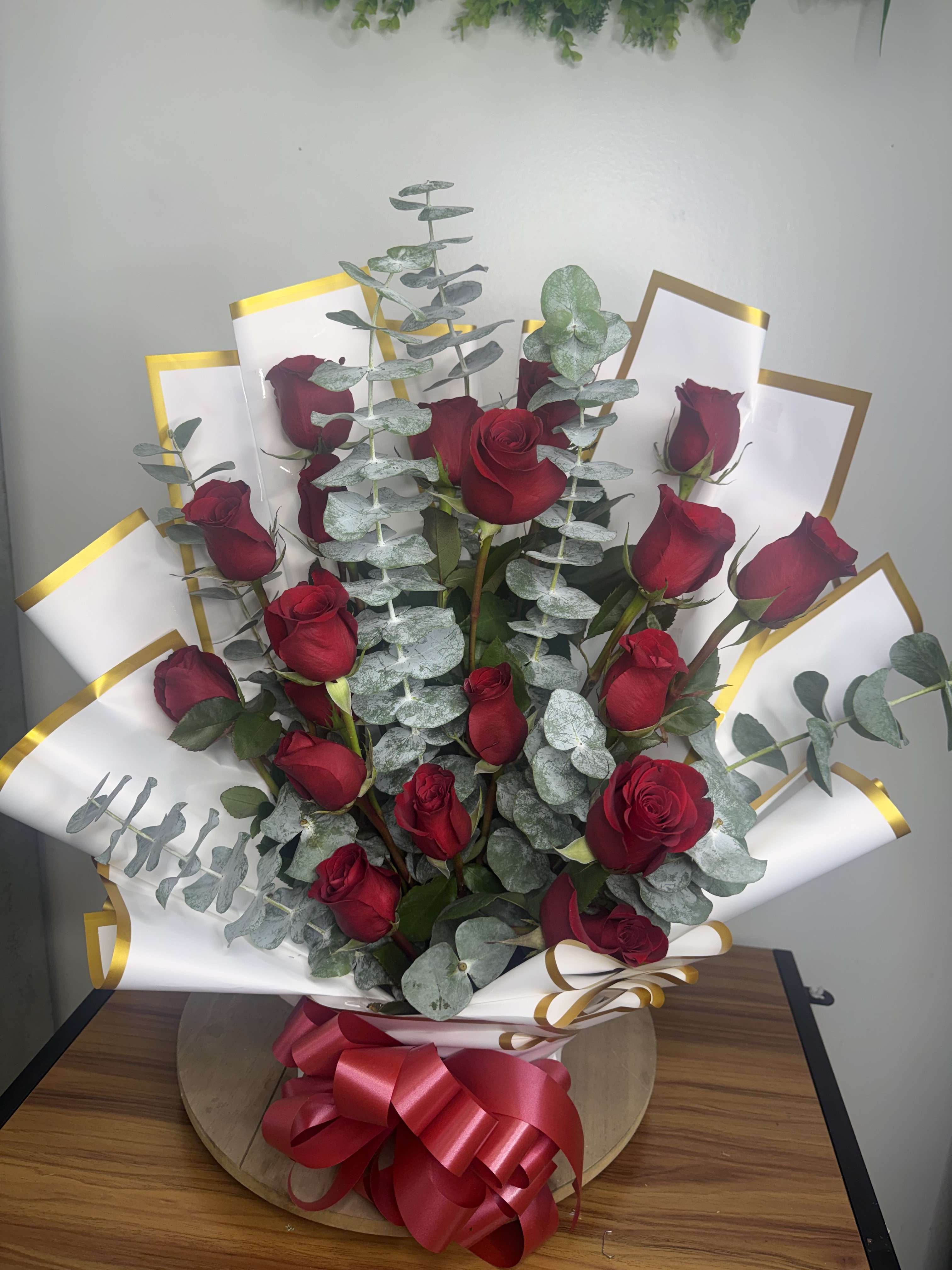 Bouquet of red roses with eucalyptus and white-gold wrap