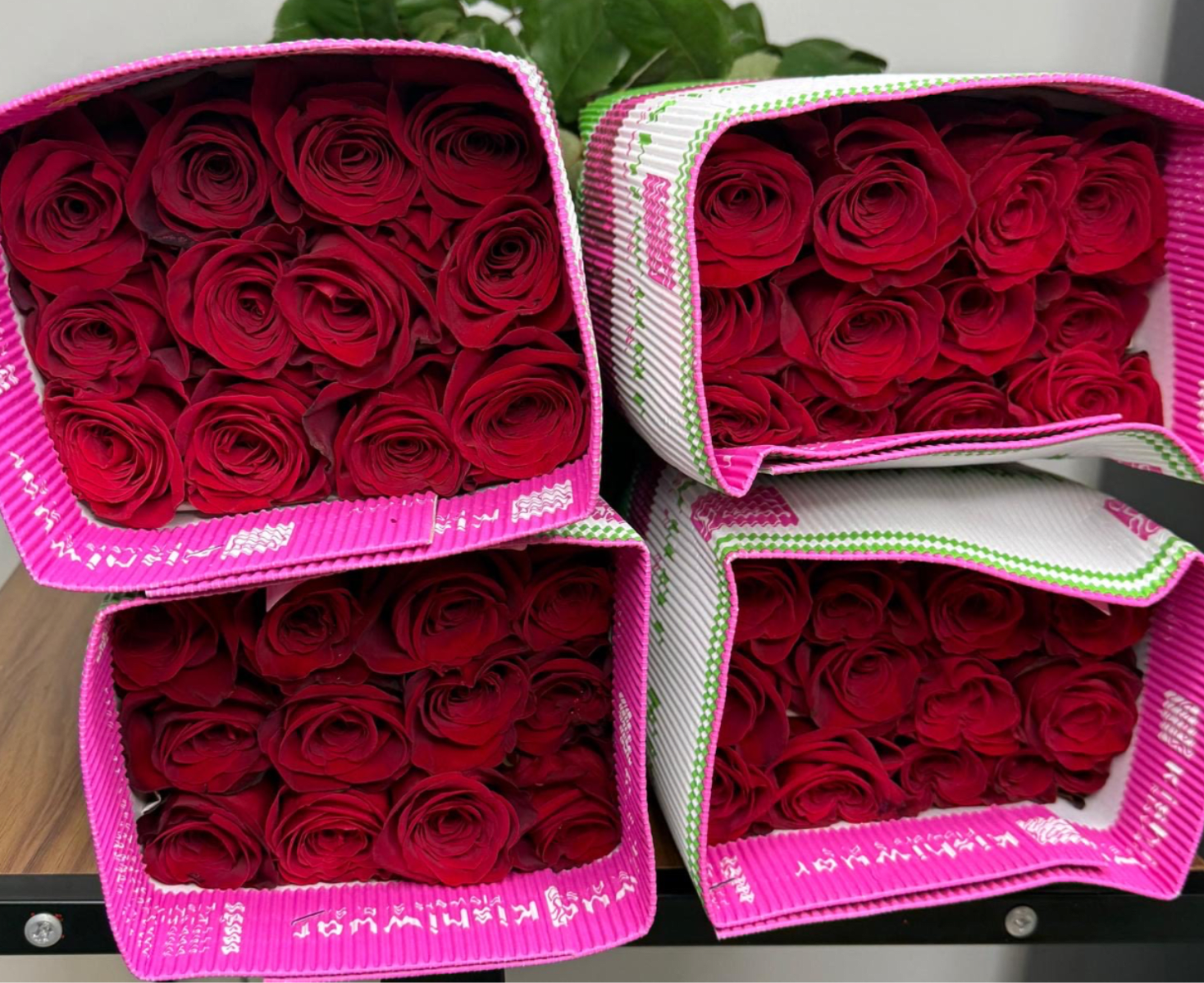 Four boxes of red roses arranged in a stacked display