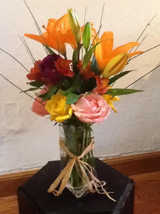 Colorful bouquet of lilies and roses in a glass vase
