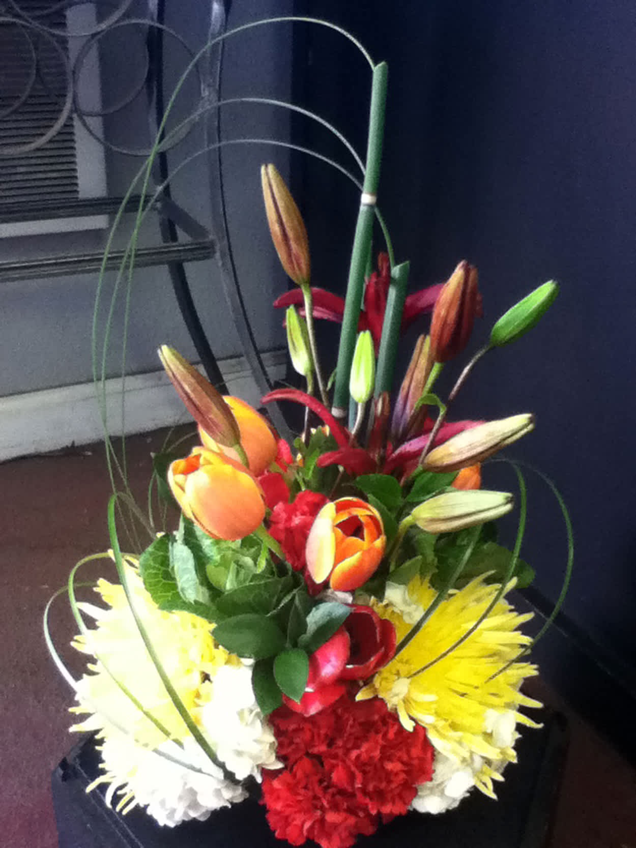 Tall bouquet with lilies, tulips, chrysanthemums, and carnations in bright colors