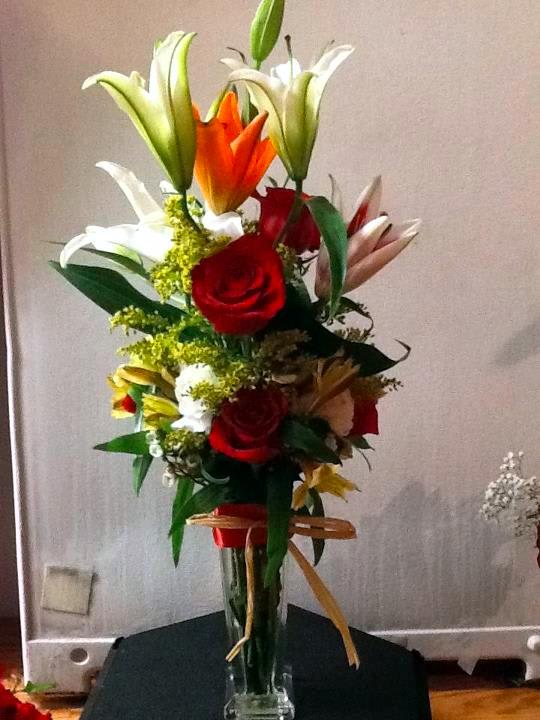 Tall bouquet of lilies and roses in a clear glass vase
