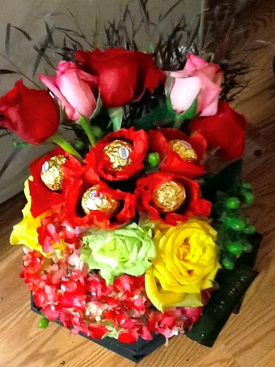 Bouquet of red and pink roses with wrapped chocolates