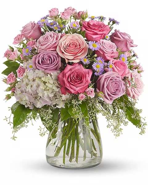 Bouquet of pink and lavender roses in a clear glass vase