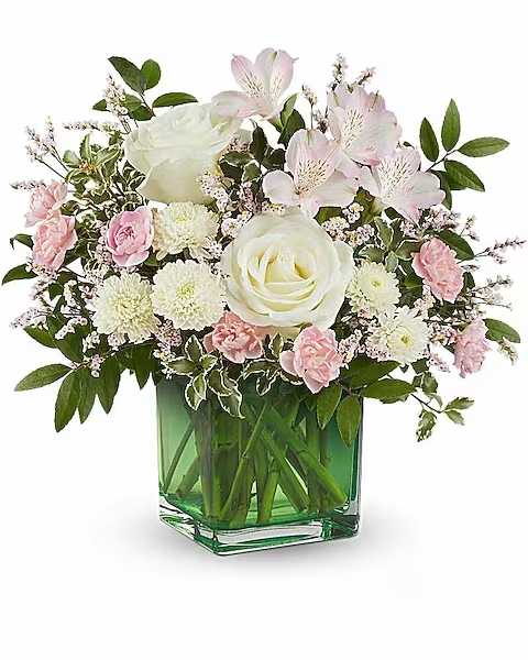 Teleflora's Pops Of Pink Bouquet - Soft and elegant, this lovely rose bouquet features gentle pops of pink and white, beautifully arranged in a classic citrus green cube. It adds a serene touch of garden charm to any setting. This arrangement features white roses, light pink alstroemeria, miniature pink carnations, white button spray chrysanthemums, pink limonium, huckleberry, and pitta negra. Delivered in a citrus cube, this bouquet doubles as a charming votive or decorative piece.   Orientation : All-Around  All prices in USD ($)  Due to an increase in the cost of roses, some product prices may be impacted during the Valentine’s delivery period.