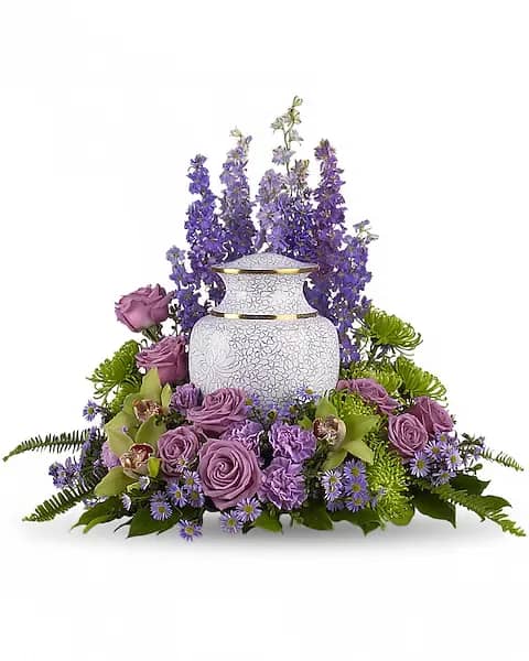 Purple floral arrangement around a white urn