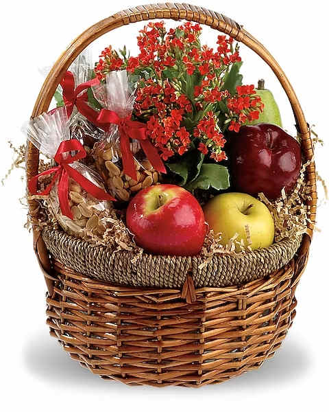 Fruit basket with red flowers and wrapped nuts in a wicker basket