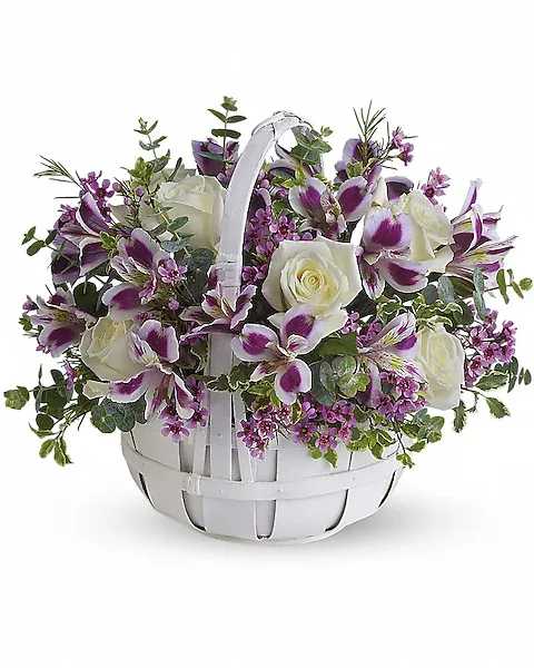 White basket of purple and white flowers with a handle