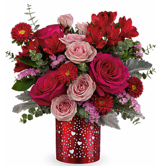 Bouquet of pink and red roses with red daisies in a heart-patterned vase