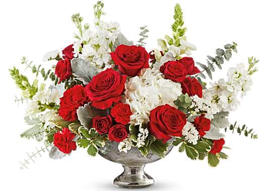Red roses and white flowers in a silver pedestal vase