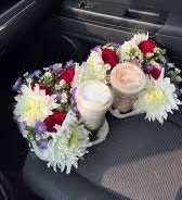 Two floral arrangements with white and red blooms on car seats