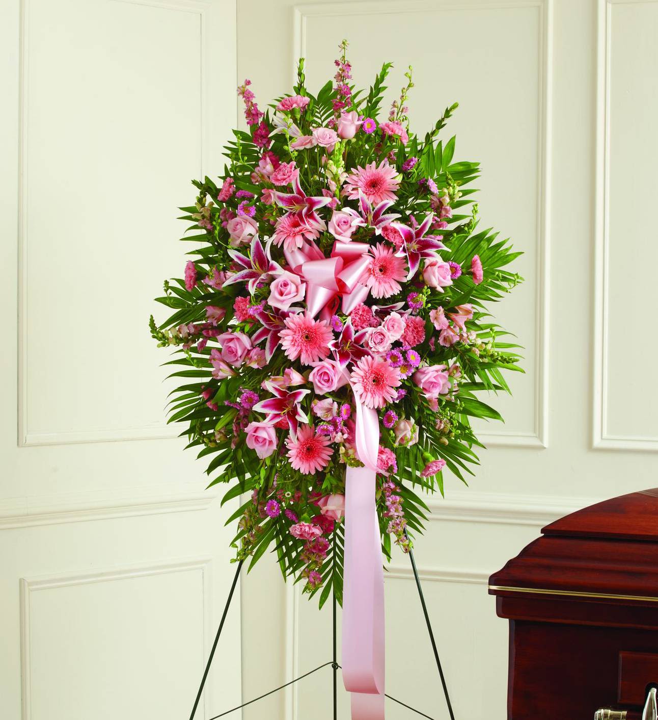 Pink floral standing spray on an easel with a ribbon