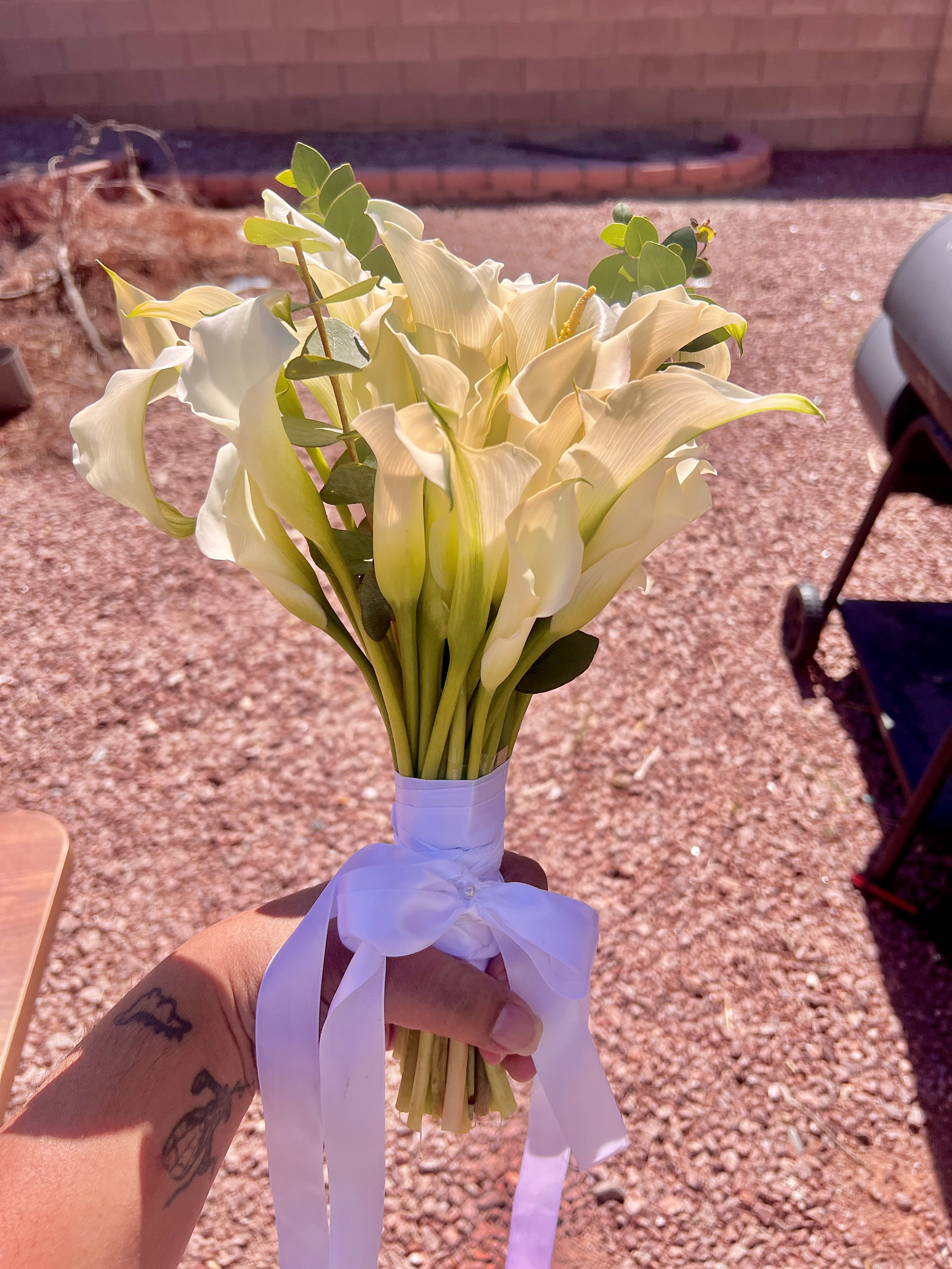 Bouquet of white calla lilies tied with a white ribbon