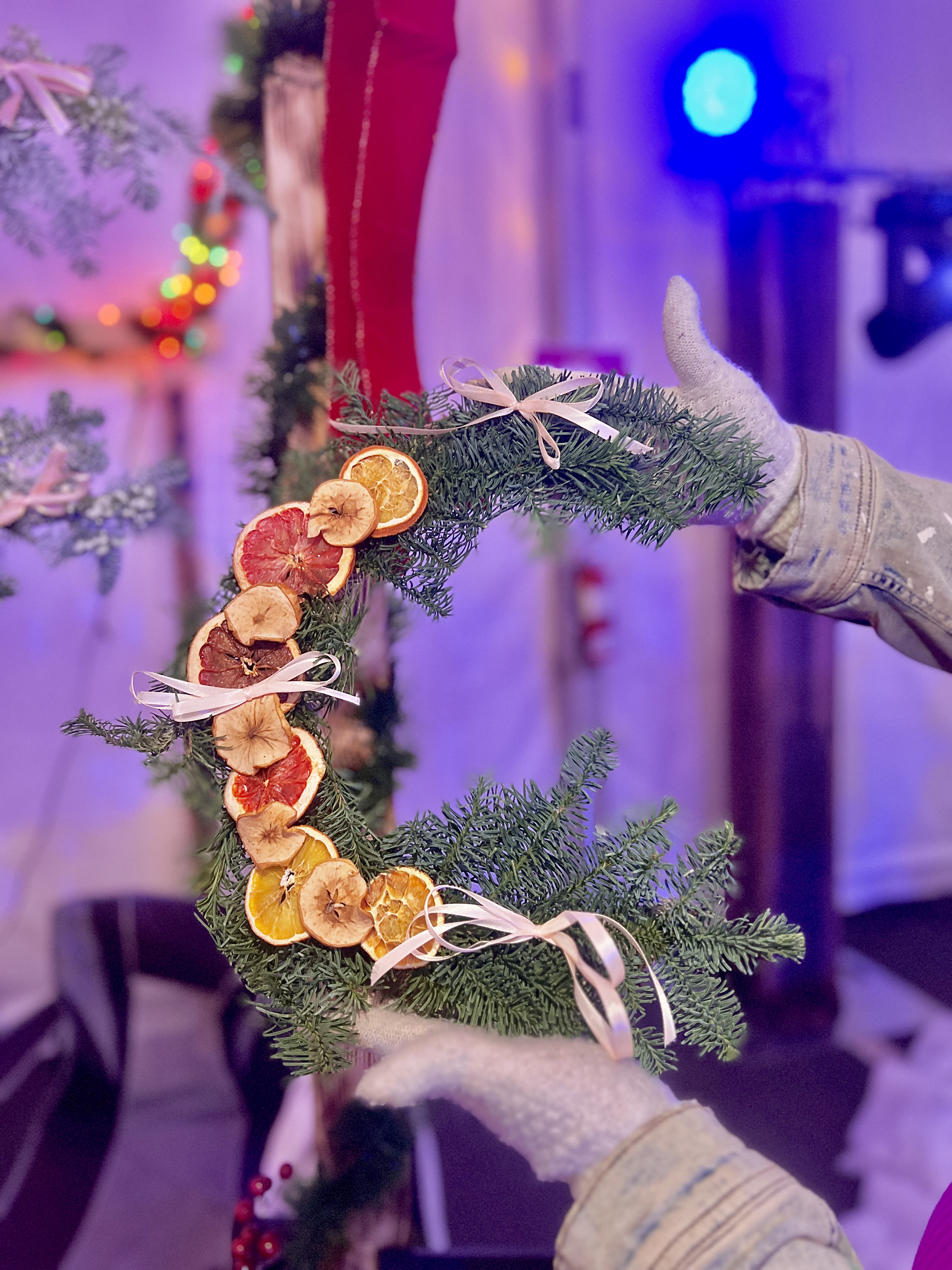 Crescent evergreen wreath with dried citrus slices and pale ribbon bows