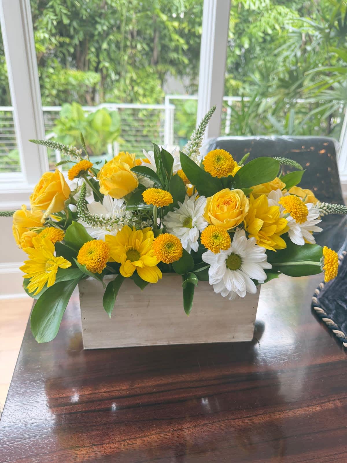 Yellow roses and white daisies in a rectangular wooden planter