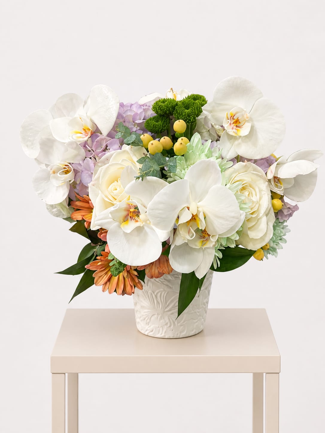 White Orchid &amp; Rose Arrangement - This refined arrangement features luxurious white orchids, soft ivory roses, delicate hydrangea, and seasonal accents, thoughtfully designed in an elegant ceramic vase.  A graceful and sophisticated design, perfect for : sympathy, get well, birthday, just because, love &amp; romance. This is a Designer’s Choice arrangement. Each piece is thoughtfully created using the freshest blooms available, while maintaining the overall look and feel of the design.  Available for local flower delivery throughout Naples, Bonita Springs, Estero, Fort Myers and Fort Myers Beach.  Designer’s Choice: Each arrangement is uniquely designed using the freshest seasonal flowers available. Flower varieties, colors and containers may vary while maintaining the overall style, value and beauty of the design. 
