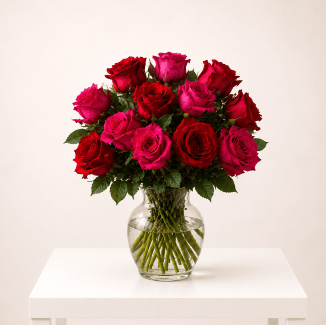 Fuchsia &amp; Red Rose Garden in Clear Vase - A striking floral arrangement designed with 12 premium roses featuring a romantic mix of deep red and vibrant fuchsia roses accented with fresh greenery, eucalyptus, and green button blooms in a modern clear glass vase. Designed with a naturally gathered garden-style look, this arrangement highlights visible stems in water for an elegant and organic floral presentation. Its rich color palette and softly imperfect styling create a luxurious yet fresh design perfect for gifting and special celebrations.  Better For: Mother’s Day, Romantic Gift, Anniversary, Birthday, Luxury Floral Gift, Thinking of You, Special Celebration  Available for local flower delivery throughout Naples, Bonita Springs, Estero, Fort Myers and Fort Myers Beach.  Designer’s Choice: Each arrangement is uniquely designed using the freshest seasonal flowers available. Flower varieties, colors and containers may vary while maintaining the overall style, value and beauty of the design.