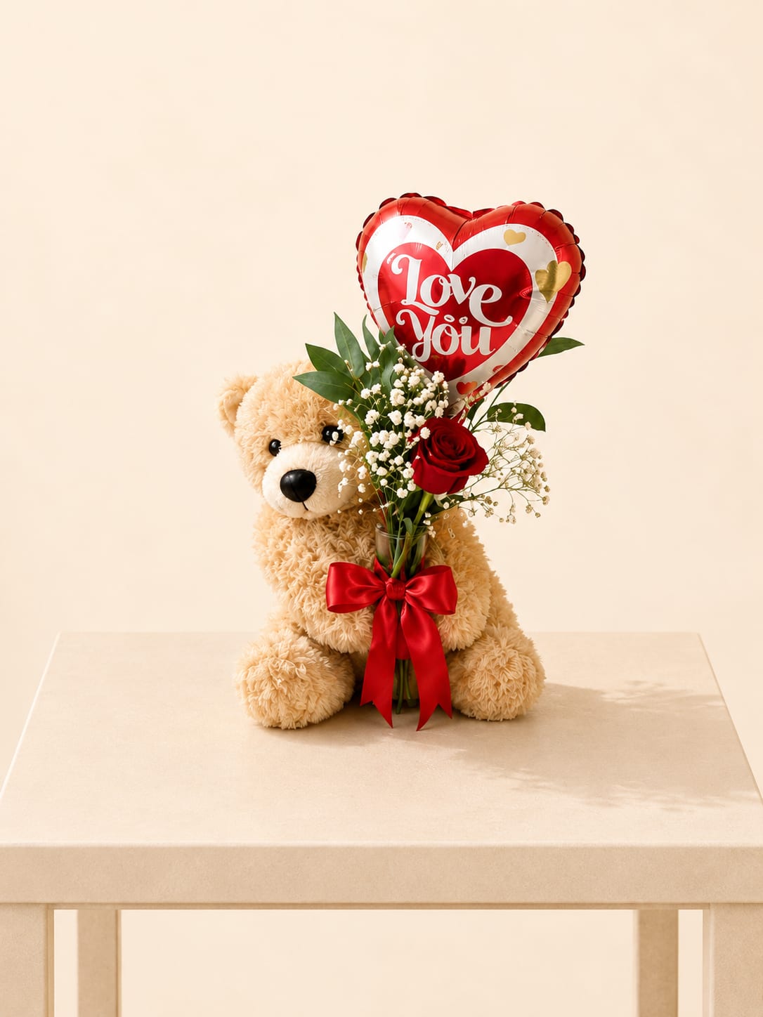 Teddy + “Love You” Balloon + Rose - A sweet romantic gift featuring a plush teddy bear, a heart-shaped “Love You” foil balloon, and a red rose accented with baby’s breath and fresh greenery—arranged in a clear glass vase and finished with a red bow.   Bear designs may vary, but the love and charm remain.  Better for: Valentine’s Day, anniversaries, romantic surprises, “I love you,” birthdays, just because, thank you, apology.