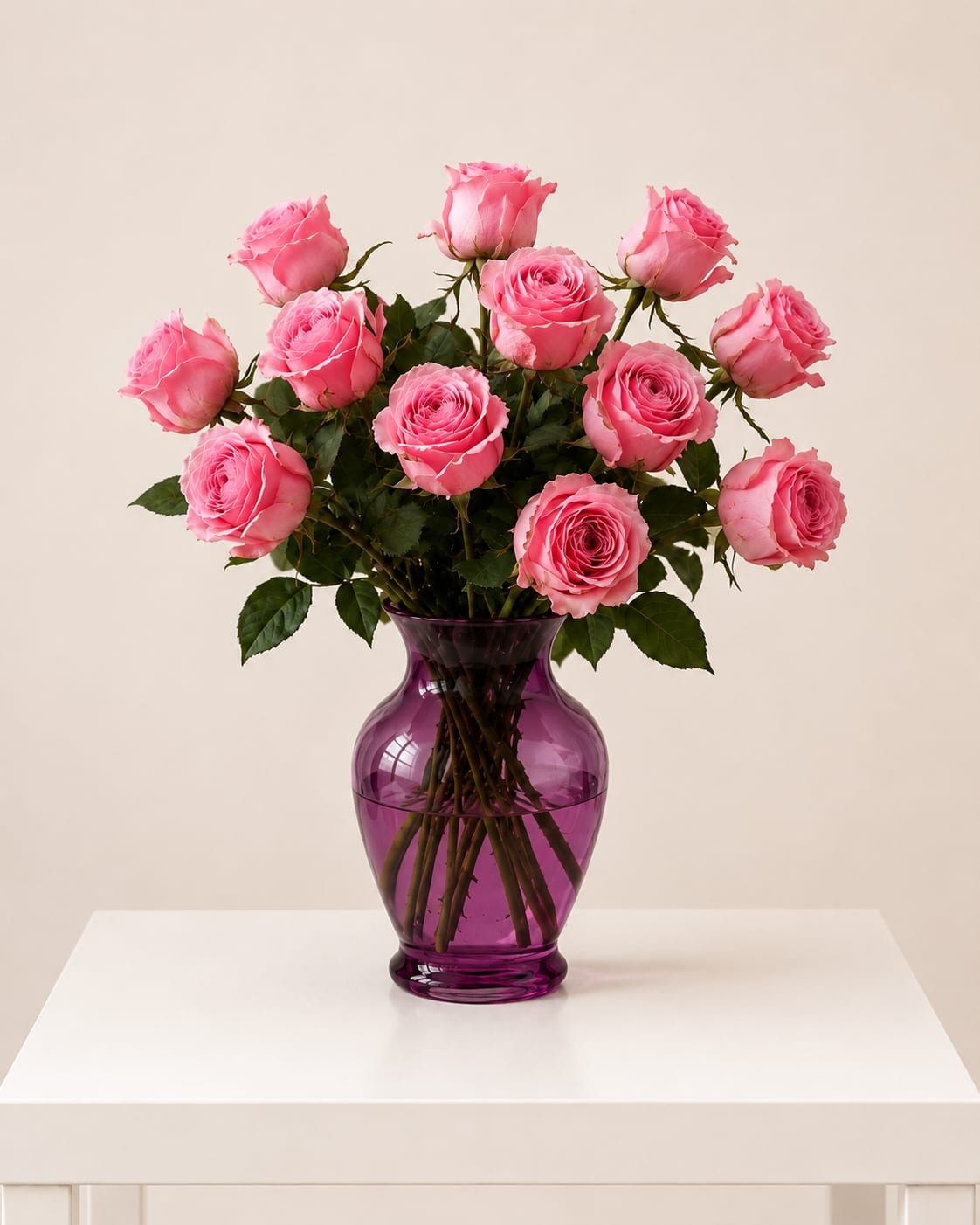 Pink roses arranged in a purple glass vase