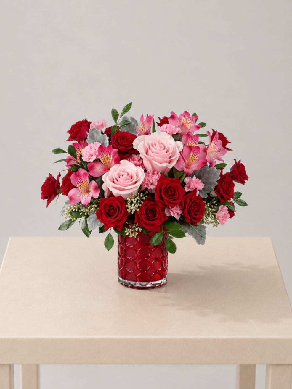 Blush &amp; Crimson Romance  - A charming flower arrangement featuring red and blush roses, accented with soft pink alstroemeria and lush greenery, beautifully designed in a patterned red vase. Full of love and warmth, this design creates a romantic and eye-catching statement.  Perfect for Valentine’s Day, anniversaries, romantic gestures, congratulations, Mother’s Day, or a heartfelt “just because” surprise.  Available for local flower delivery throughout Naples, Bonita Springs, Estero, Fort Myers and Fort Myers Beach.  Designer’s Choice: Each arrangement is uniquely designed using the freshest seasonal flowers available. Flower varieties, colors and containers may vary while maintaining the overall style, value and beauty of the design.